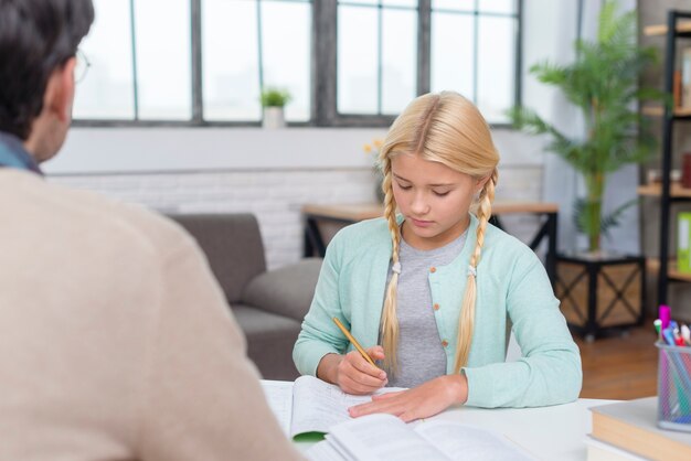 Joven estudiante rubia aprendiendo de su tutor