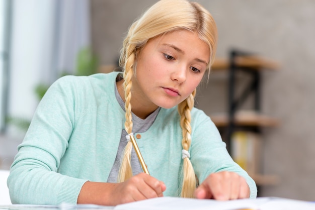 Foto gratuita joven estudiante rubia tomando notas