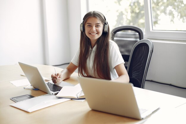 Joven estudiante sentado en la mesa y usar la computadora portátil