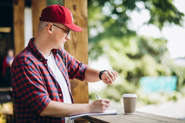 Joven estudiante trabajando en una cafetería en el parque