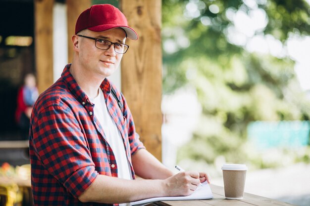 Joven estudiante trabajando en una cafetería en el parque