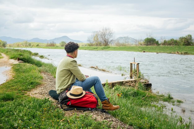 Joven excursionista emplazamiento cerca del hermoso río