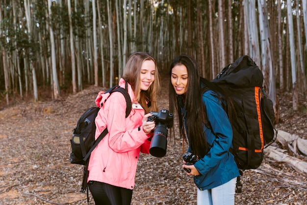 Joven excursionista femenina mostrando la fotografía en la cámara a su amigo