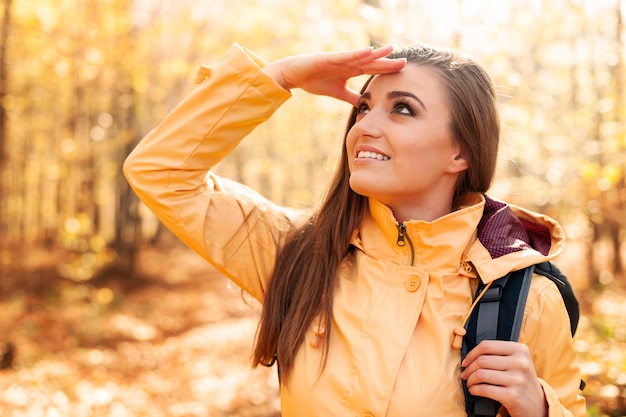 Joven excursionista mujer sonriente mirando lejos