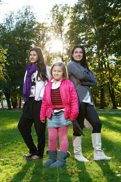 Joven familia dando un paseo saludable por el parque de otoño