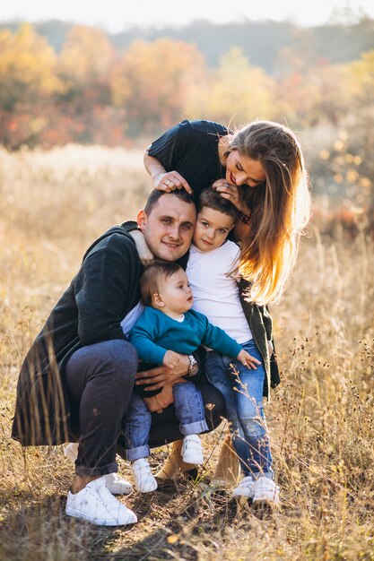 Joven familia con dos hijos juntos en el parque