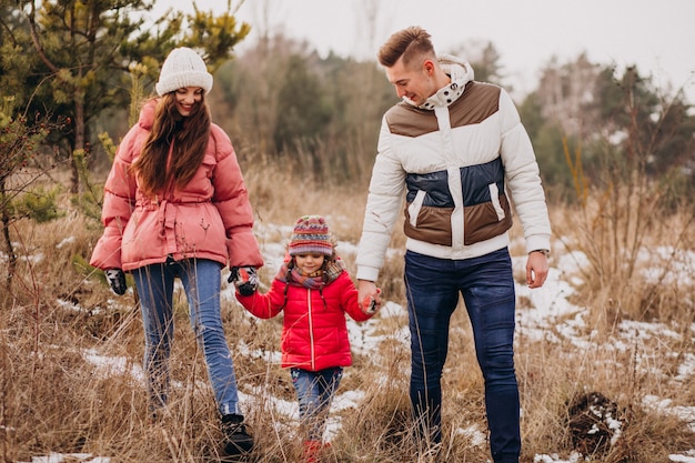 Joven familia juntos caminando en el bosque en invierno