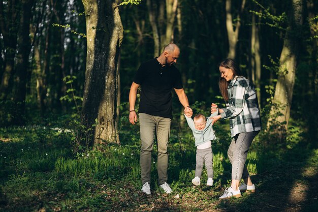 Joven fanily con pequeña hija en el bosque