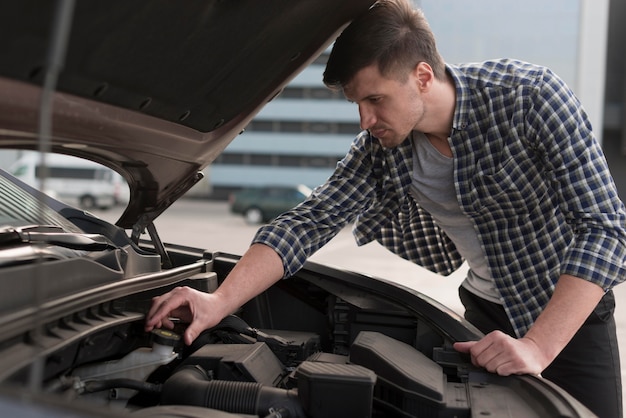 Foto gratuita joven, fijación de coche