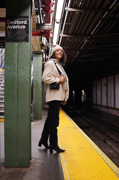 Joven fotógrafa con estilo explorando el metro de la ciudad