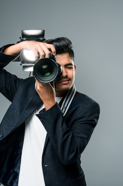 Joven fotógrafo indio profesional tomando fotos en el estudio con leight