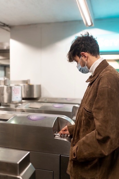 Foto gratuita joven francés entrando al metro y usando su boleto