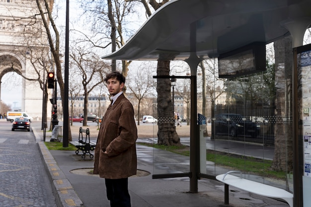 Joven francés esperando en la estación para el autobús