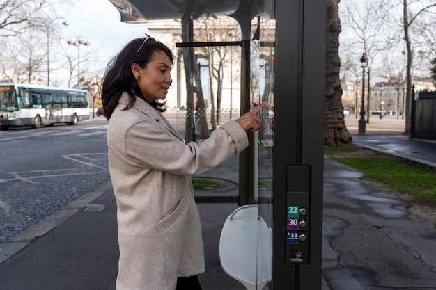 Joven francesa esperando el autobús en la estación y consultando el mapa de la estación