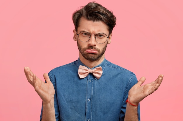 Joven con gafas redondas y pajarita rosa