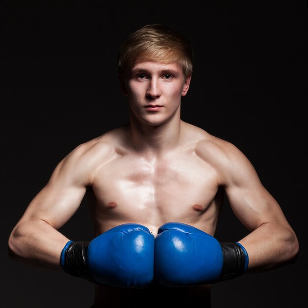 Joven guapo boxeador en guantes azules