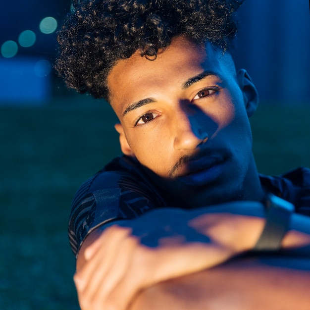 Foto gratuita joven guapo con los brazos cruzados al atardecer