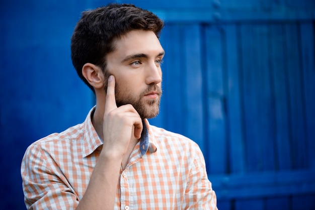 Joven guapo en camisa a cuadros pensando