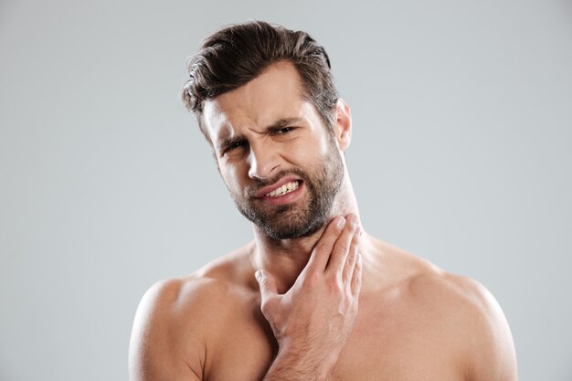 Joven guapo desnudo experto su cara antes de afeitarse