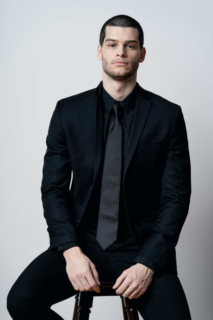 Foto gratuito joven y guapo hombre de negocios con camisa negra y traje negro.
