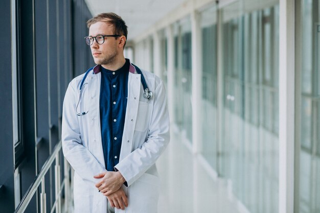 Joven guapo médico con estetoscopio en clínica