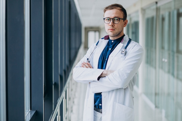 Joven guapo médico con estetoscopio en clínica