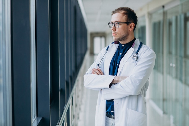 Joven guapo médico con estetoscopio en clínica