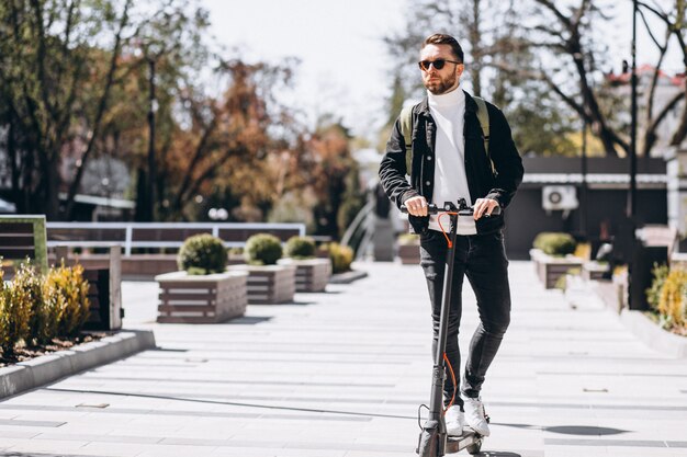 Joven guapo montando en moto en el parque