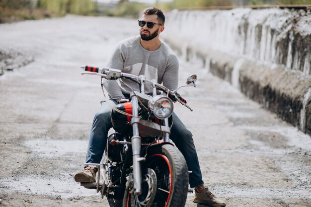 Joven guapo en moto viajando