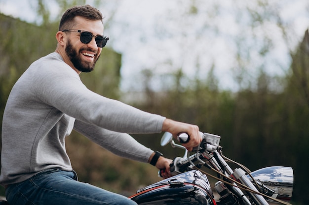 Joven guapo en moto viajando