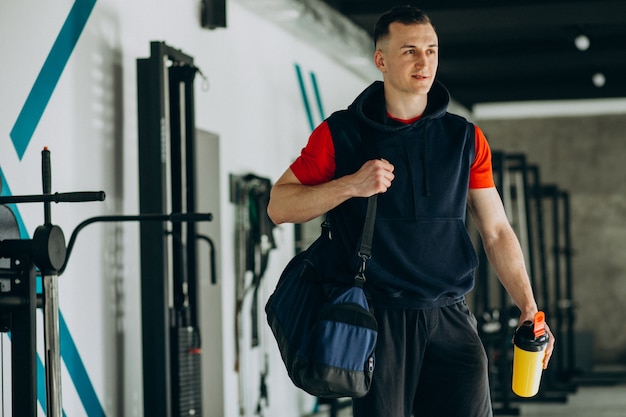 Joven guapo en ropa deportiva en el gimnasio