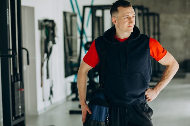 Joven guapo en ropa deportiva en el gimnasio