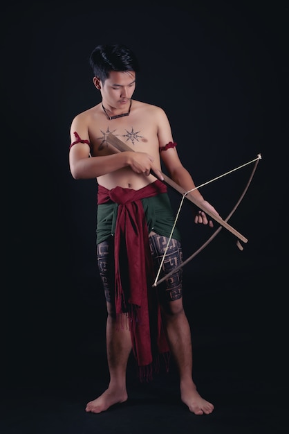 Joven guerrero masculino de Tailandia posando en una posición de combate con una espada