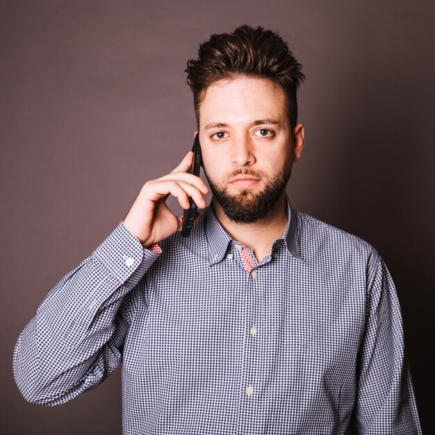 Joven hablando por teléfono en el estudio