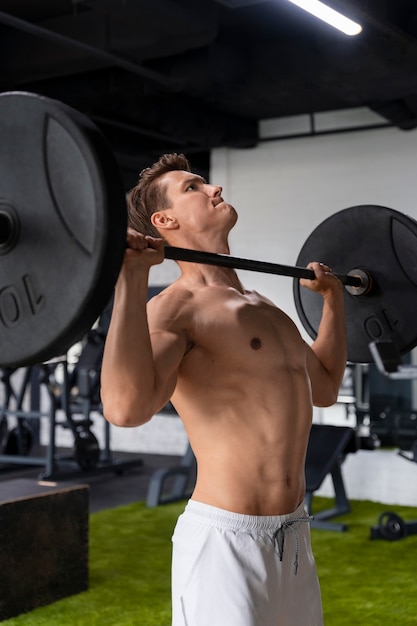 Foto gratuita joven haciendo ejercicio en el gimnasio para culturismo