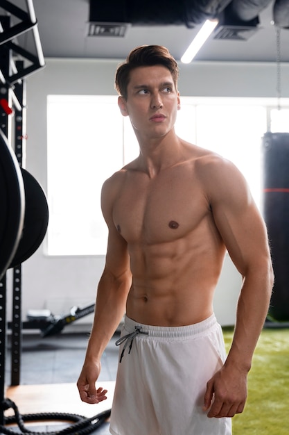 Joven haciendo ejercicio en el gimnasio para culturismo