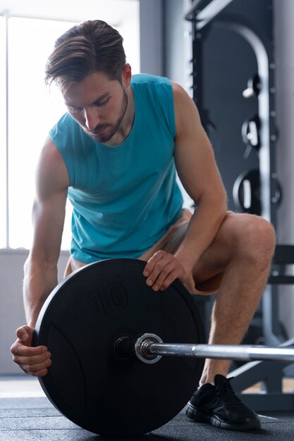 Joven haciendo ejercicio en el gimnasio para culturismo