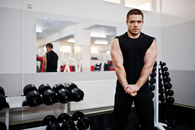 Joven haciendo ejercicios y trabajando duro en el gimnasio y disfrutando de su proceso de entrenamiento