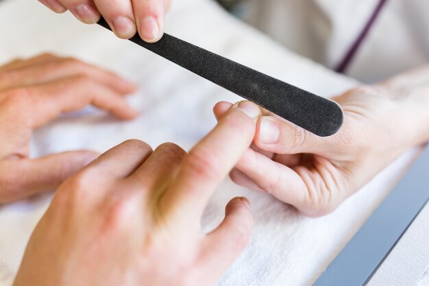 Joven haciendo manicura en el salón. Concepto de la belleza.