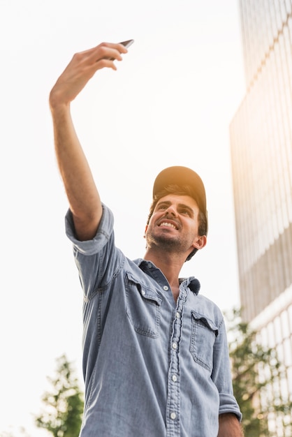 Foto gratuita joven haciendo una selfie afuera