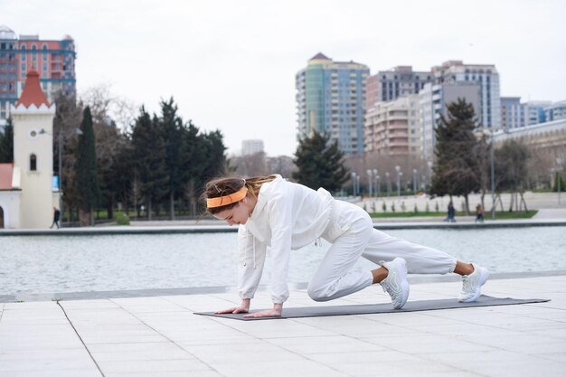 Una joven haciendo sus ejercicios en el parque frente al lago Foto de alta calidad