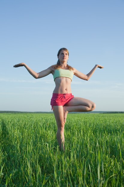 Joven haciendo yoga contra la naturaleza