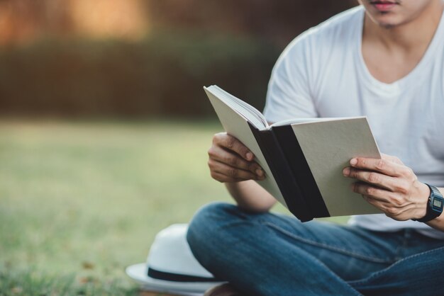 Joven Hansome hombre leyendo libro