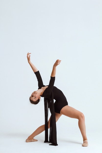 Joven hermosa bailarina contemporánea posando sobre la pared blanca. Copia espacio