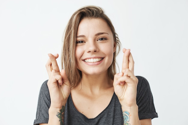 Joven hermosa chica emotiva rezando sonriendo.