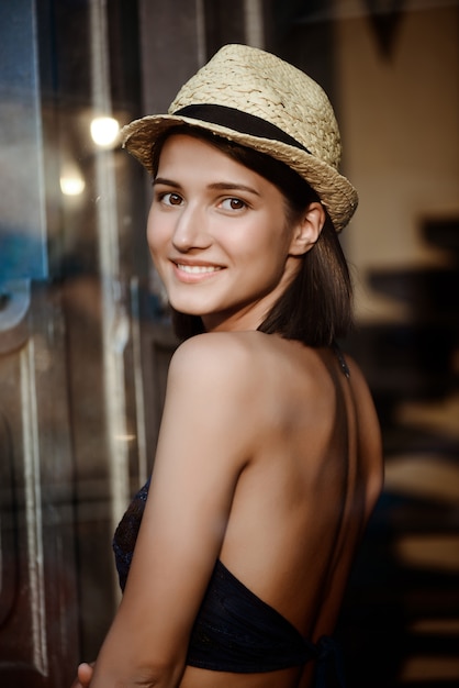 Joven hermosa chica morena con sombrero sonriendo.