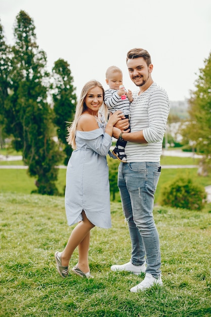 Una joven y hermosa madre rubia con un vestido azul, junto con su hombre guapo