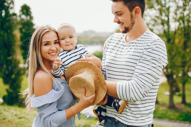 Una joven y hermosa madre rubia con un vestido azul, junto con su hombre guapo