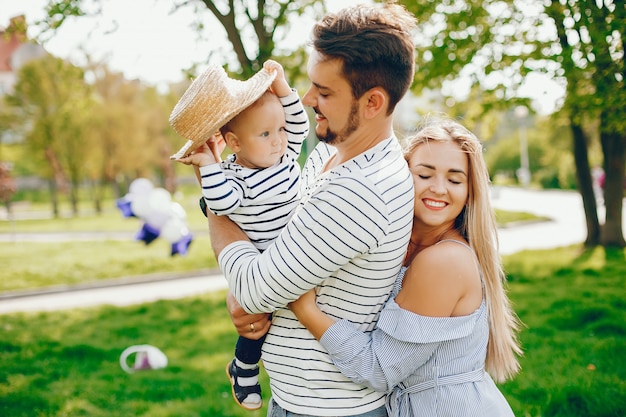 Una joven y hermosa madre rubia con un vestido azul, junto con su hombre guapo