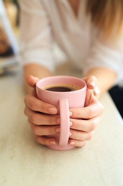 Joven hermosa mujer bebiendo café o té